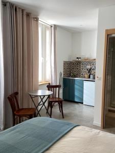 een slaapkamer met een bed en een tafel en stoelen bij Studio - Cœur de Ville in Sérignan