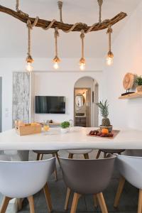 una sala da pranzo con tavolo e sedie bianchi di Luxury Naxos Villa | 4 Bedrooms | Villa Charlotte Linlin | Panoramic Sea Views | Naxos ad Agia Anna Naxos