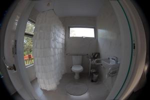 a small bathroom with a toilet and a window at Casa Ócio By Canela do Mato in Palomas
