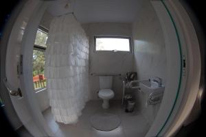 ein kleines Badezimmer mit Toilette und Fenster in der Unterkunft Casa Ócio By Canela do Mato in Palomas