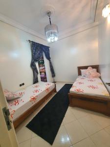 a bedroom with two beds and a chandelier at Residence Bouanane B in Fez