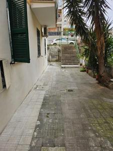 an empty alley with a building and a palm tree at Licheni house in Rome