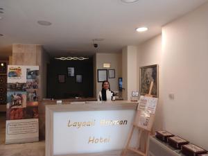 a woman sitting at a counter in a hotel at Layaali Amman Hotel in Amman