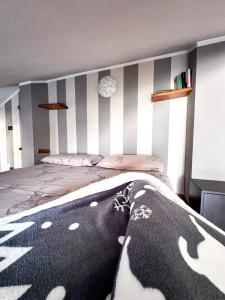 1 dormitorio con 1 cama con pared a rayas en StudiÒ Archet, en Aosta