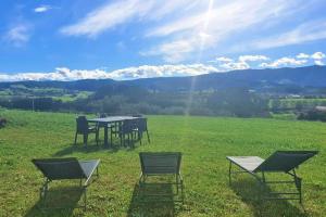 ein Tisch und Stühle auf einem Feld mit Bergen im Hintergrund in der Unterkunft Casita Madrigal in Lamadrid