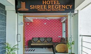 a hotel entrance with a bench under a sign at Hotel Shree Regency Ahmedabad in Ahmedabad