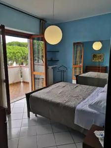 Schlafzimmer mit einem Bett und einer Tür zu einem Balkon in der Unterkunft Bilocale centrale 80 MQ, con terrazza abitabile in Tortoreto Lido