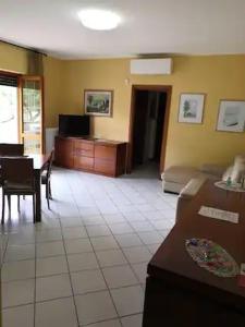 ein Wohnzimmer mit einem Sofa und einem Tisch in der Unterkunft Bilocale centrale 80 MQ, con terrazza abitabile in Tortoreto Lido