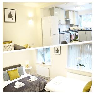 twee foto's van een kamer met een bed en een keuken bij The Close Airport in Harmondsworth