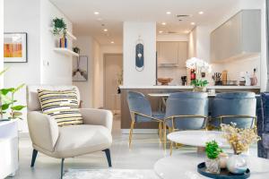 een woonkamer en een keuken met blauwe stoelen en een tafel bij Mystic - Forte Tower 2 in Dubai