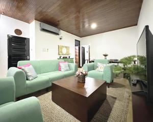 - un salon avec des canapés verts et une table basse dans l'établissement Aadaraya Colombo 7, à Colombo