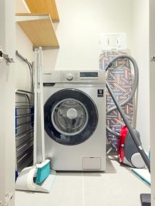 een wasmachine in een wasruimte met kabels bij Mystic - Forte Tower 2 in Dubai