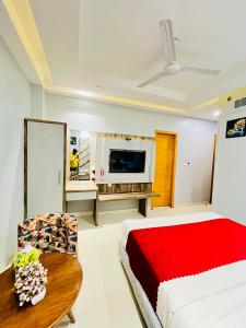 a bedroom with a bed and a table and a tv at Hotel NASHA Unit By Worth New Delhi in New Delhi