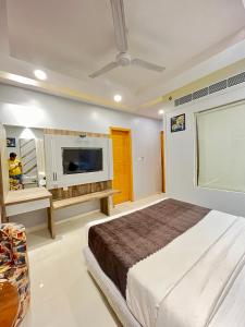 a bedroom with a bed and a flat screen tv at Hotel NASHA Unit By Worth New Delhi in New Delhi