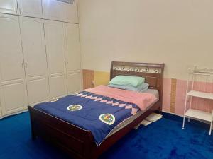 a bedroom with a bed with a blue carpet at Deira Salahuddin Comfort Residences in Dubai