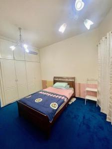 a bedroom with a bed with a blue carpet at Deira Salahuddin Comfort Residences in Dubai