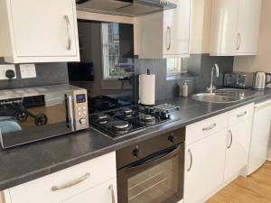 A kitchen or kitchenette at Bright, spacious apartment with off-road parking