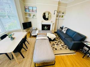 a living room with a couch and a table at Bright, spacious apartment with off-road parking in Bath