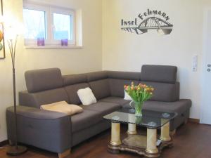 a living room with a couch and a table with flowers at Ferienwohnung Welle OG in Fehmarn