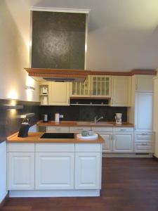 a kitchen with white cabinets and a stove at Ferienwohnung Welle OG in Fehmarn