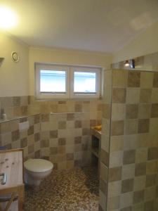 un bagno con un water, un lavandino e una finestra di Ferienwohnung Welle OG a Fehmarn Altre 18 foto