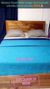 Una cama en una habitación con un cartel que lee Saint Laurent du Martin en Ouest Nelis Lodge, en Saint-Laurent-du-Maroni