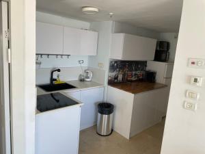 a small kitchen with white cabinets and a sink at מגדלי המרינה in Herzliyya B