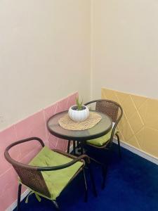 un tavolo con due sedie e un vaso sopra di Salahuddin Metro Home Stay a Dubai
