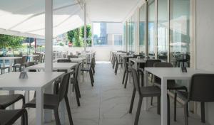pusta restauracja ze stołami, krzesłami i oknami w obiekcie Hotel Ninfea Cattolica w mieście Cattolica