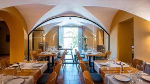 restauracja ze stołami i krzesłami oraz dużym oknem w obiekcie Abbatissa Hotel Restaurant w mieście Sant Joan de les Abadesses