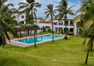uma vista aérea de um resort com uma piscina e palmeiras em Haradali Suites 2 Bedroom Beach Apartment - Sultan Palace Beach Resort em Kilifi