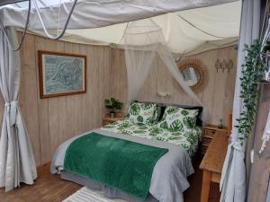 ein Schlafzimmer mit einem Himmelbett in der Unterkunft Vrijstaande accommodatie Glamping de Kas InN in Hank