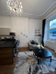 a living room with a couch and a chandelier at Sauchiehall Street Apartment in Glasgow