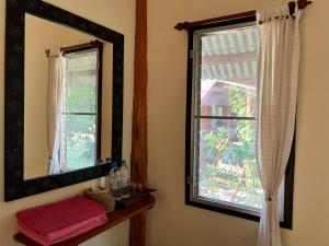 a bathroom with a mirror and a window at Baan rabiang Pai บ้านระเบียงปาย in Pai