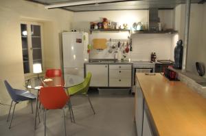 una cucina con tavolo, sedie e frigorifero di Loft-House - Maison Vigneronne Village UNESCO a Rivaz