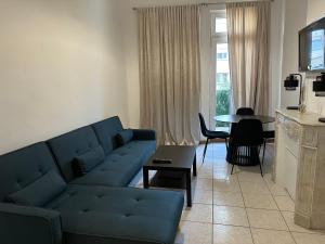 a living room with a blue couch and a table at Appartement cosy - 3e arr in Marseille