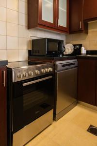 a kitchen with a stove and a microwave at Modern 2BR Oasis with Breathtaking Views in JBR - 12AB10 in Dubai