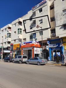 a street with cars parked in front of a building at Residence Bouanane B in Fez