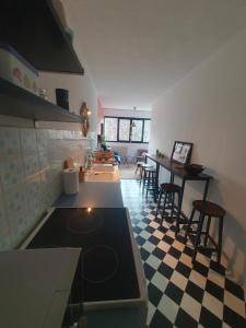 een keuken met een fornuis en een geruite vloer bij L'atelier cosy in Beaune
