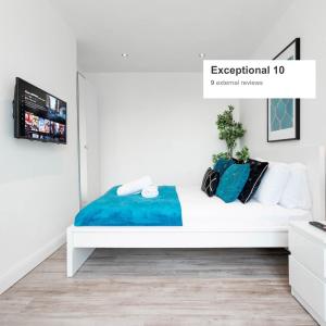 una camera da letto con un letto bianco e lenzuola blu di 4 Bedroom House - Parking & Garden - Smart TVs - Netflix - Wifi - 22CG a Birmingham
