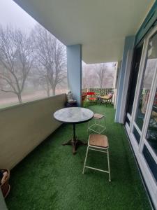 een kamer met een tafel en stoelen en groen gras bij L'atelier cosy in Beaune
