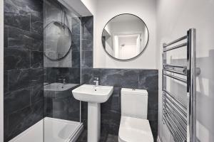 a bathroom with a sink and a toilet and a mirror at Host & Stay - Fourth Avenue Apartments in York