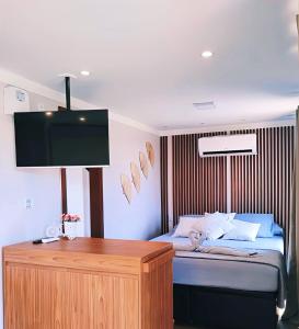 sypialnia z łóżkiem i telewizorem z płaskim ekranem w obiekcie Pousada Recanto Bela Vista w mieście Carlópolis