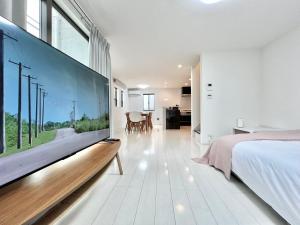 a bedroom with a large flat screen tv on a wall at Shinjuku House in Tokyo