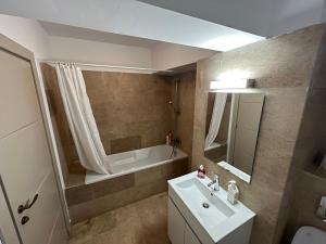 La salle de bains est pourvue d'un lavabo et d'une baignoire. dans l'établissement 2 rooms apartment Airy & Bright Chic, à Iaşi