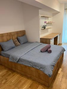 a large bed in a bedroom with a desk at 2 rooms apartment Airy & Bright Chic in Iaşi