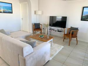 a living room with a couch and a tv at Big apartment in Sea Magic in Kyrenia