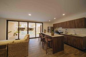 a kitchen with wooden cabinets and a bar with bar stools at Beach House “El Rosario” in La Candelaria