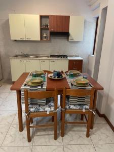 a kitchen with a wooden table and two chairs at EtnaMare petite maison in Mascali