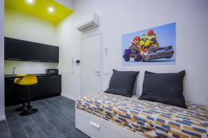Un dormitorio con una cama, un escritorio y un televisor. en Napoli Games Apartments by Dimorra, en Nápoles 116 fotos más